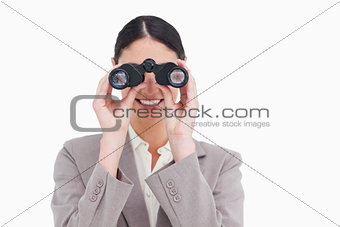 Smiling businesswoman looking through spy glasses