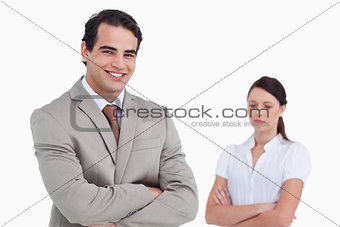 Smiling salesman with colleague behind him
