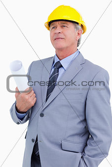 Mature architect wearing helmet and holding plans