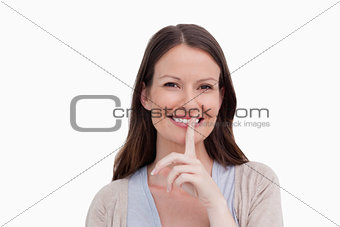 Close up of smiling woman asking for silence