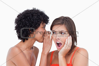 Teenager hearing a surprising secret from her friend