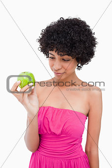 Young woman looking at her delicious green apple
