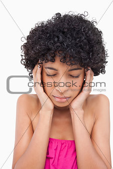 Teenager thinking while placing her hands on her temples