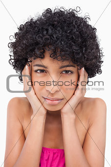 Teenager looking at the camera while thinking with her hands on 