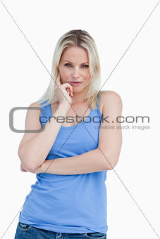 Thoughtful blonde woman placing a finger on her cheek