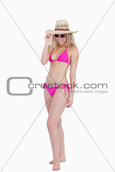 Young attractive woman holding her hat brim