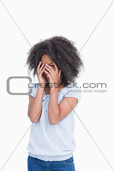 Young woman hiding her face behind her hands