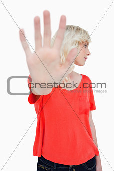 Young woman making the stop sign with hand while leaning her hea