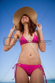 Low-angle view of a smiling teenager wearing a pink swimsuit