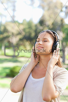 Woman with headphones enjoying music in the park