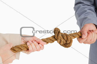 Business people tightening a knot 