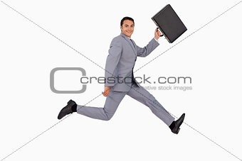 Portrait of a businessman running with a suitcase