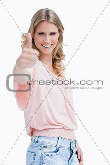 A blonde woman with her thumb up smiling at the camera
