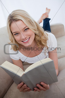 A smiling woman is holding a book
