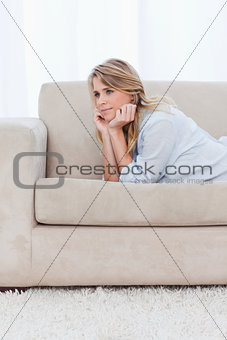 A woman resting her head on her hands is thinking