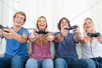A group of friends all playing video games together and smiling