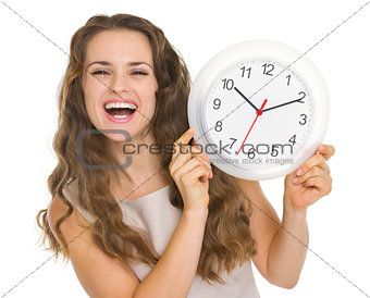 Happy young woman showing clock