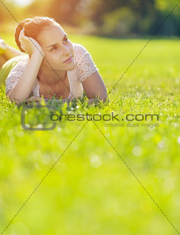 Thoughtful girl laying on meadow