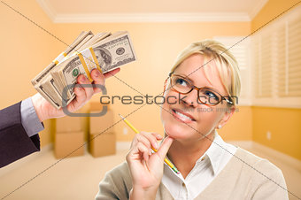 Woman Being Handed Stacks of Money in Empty Room
