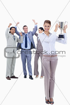 Woman holding a cup with people dressed in suits acclaiming 