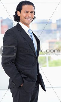 Businessman wearing a suit and standing upright in a well-lit ro