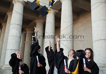 Happy graduates throwing their hats in the sky 