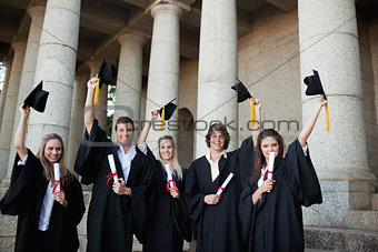 Graduates holding up their hats