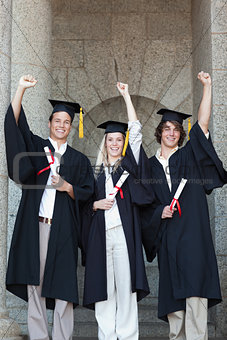 Happy graduates raising arm
