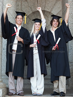 Smiling graduates raising arm