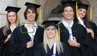 Close-up of five happy graduates posing