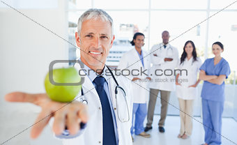 Medical team in the background looking at a doctor who is holdin