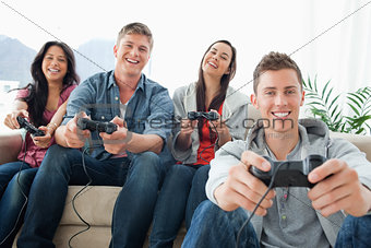 Laughing group of friends in front of the camera as they play ga