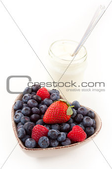 Berries in a heart shaped bowl with yogurt
