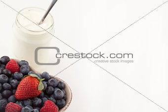 Berries in a heart shaped bowl with white yogurt