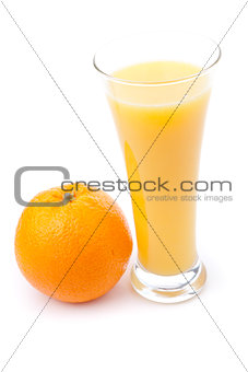Glass full of orange juice placed near an orange