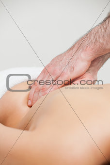 Close-up of an osteopath massaging the back of woman