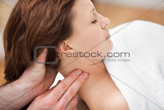 Therapist massaging the neck of woman while holding her head