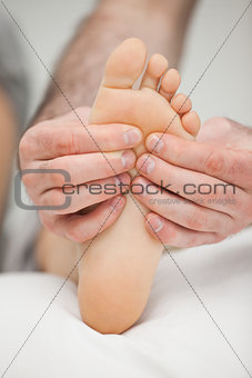 Fingers palpating the sole of a foot