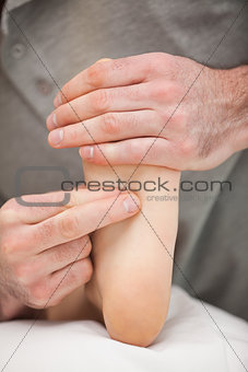Two fingers pressing the sole of a foot