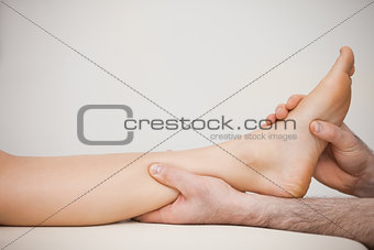 Chiropodist holding the calf of a patient
