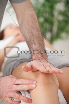Physiotherapist using his hand palm to massage a knee