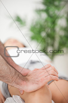 Serious doctor pressing on the knee of a woman