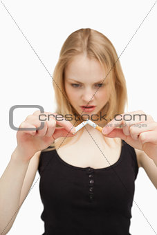 Blonde-haired woman breaking a cigarette