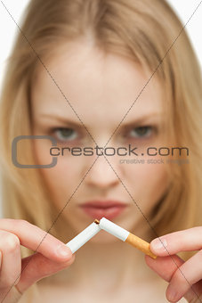 Close up of a serious woman breaking a cigarette