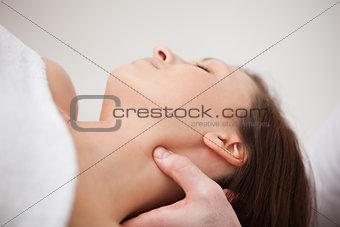 Close-up of physiotherapist pressing his thumb on the neck of a 