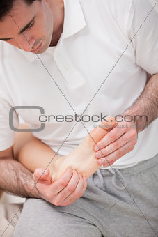 Reflexologist massaging the sole of the patient