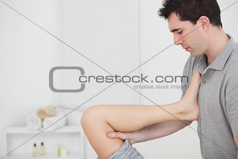 Chiropractor raising the leg of his patient against his chest