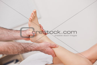 Podiatrist manipulating the ankle of his patient while holding i