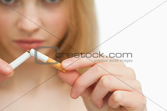 Close up of the hands of a woman breaking a cigarette