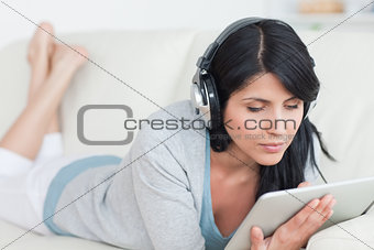 Woman wearing headphones and holding a tablet